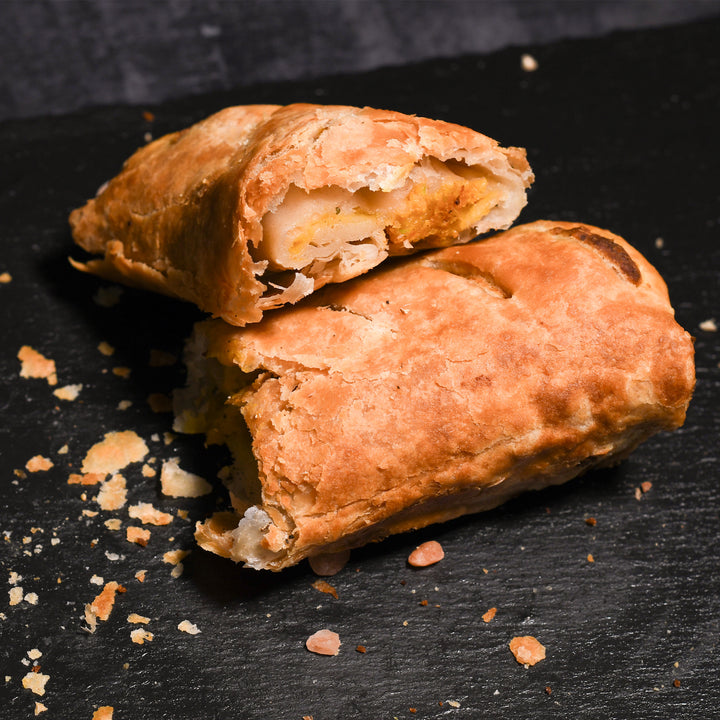 A split curry roll on a dark surface with visible filling